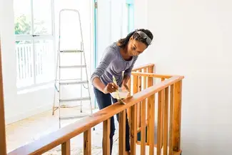 A woman painting her house