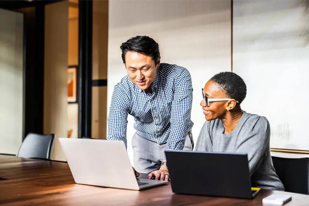 People sitting in a conference room collaborating while working on laptops