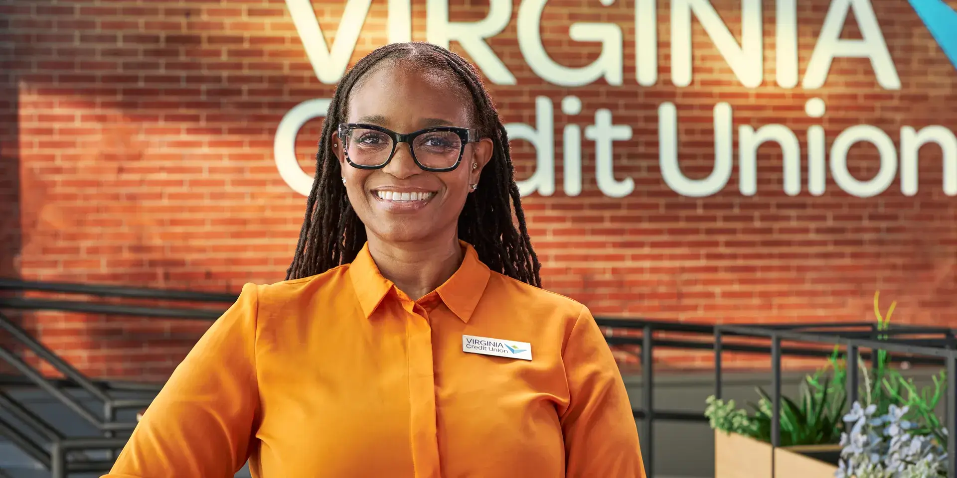 VACU employee smiling while standing inside of a branch