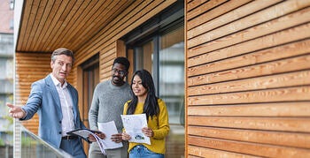 Couple walking and viewing a new home with a real estate agent